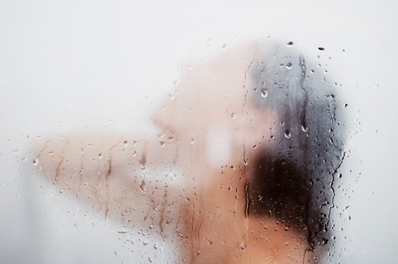 woman in a steam shower behind the shower glass