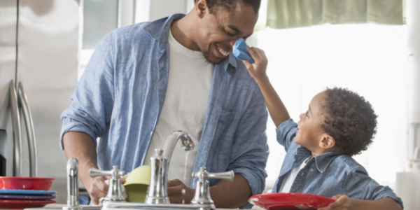 Father and son cleaning dishes together
