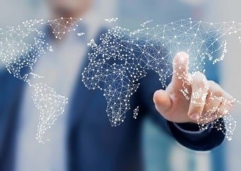 A business man pointing to a global distribution network on an electronic map