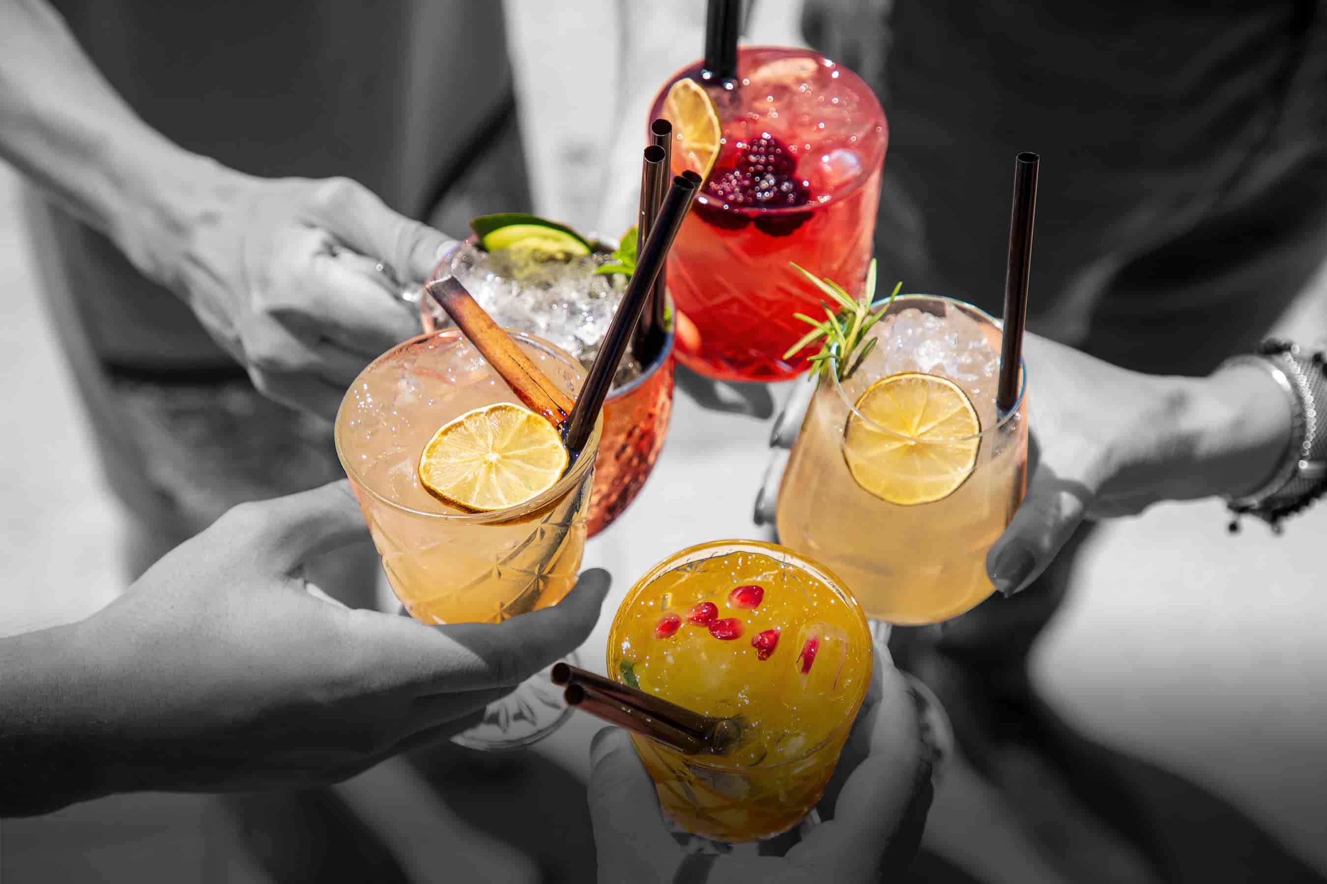 Close up of five hands in a circle holding beverages developed at the Hatchery Chicago