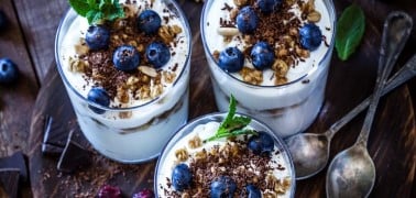 Three yogurt parfaits topped with blueberries and healthy nuts