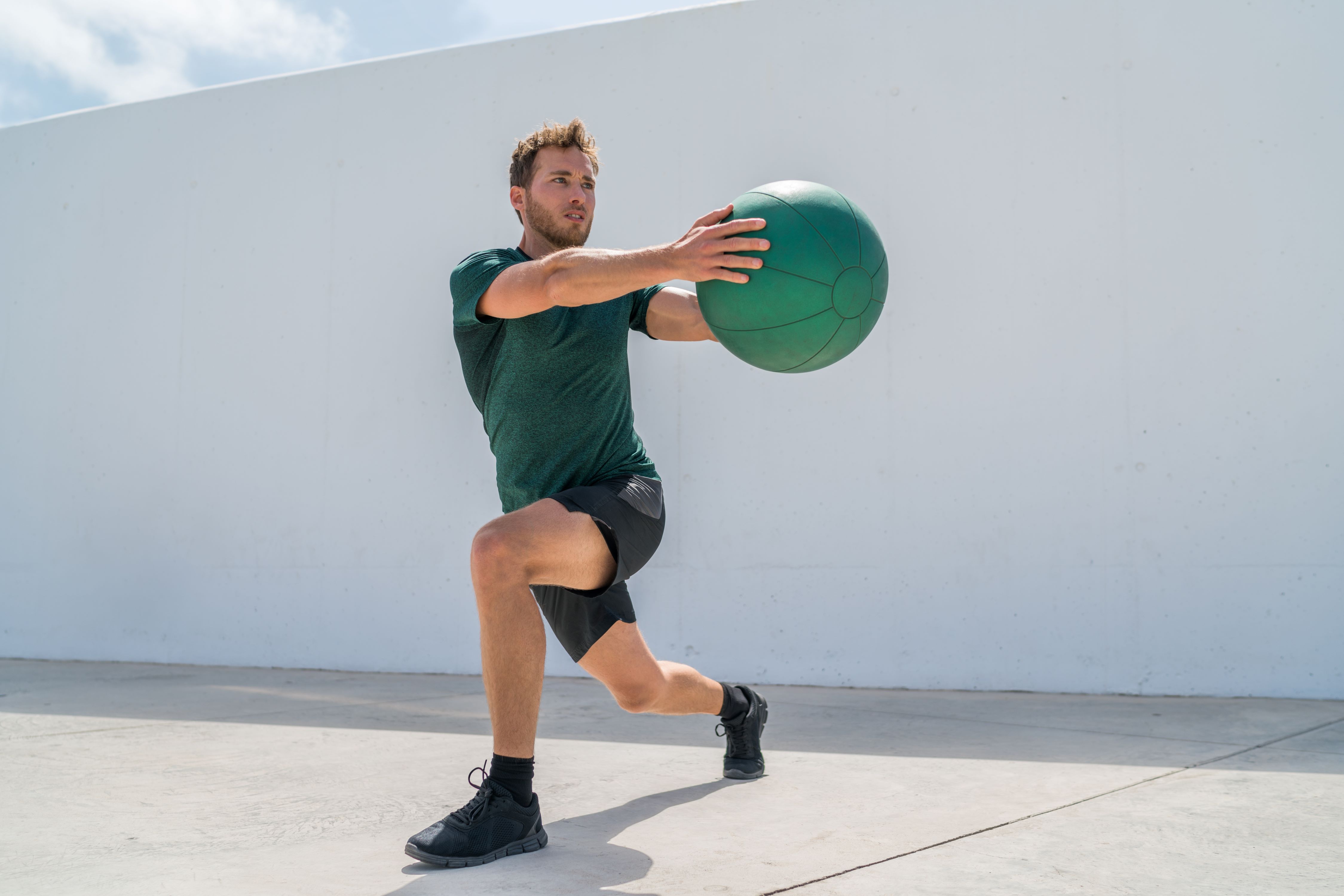 Man works out outdoors with a medicine ball