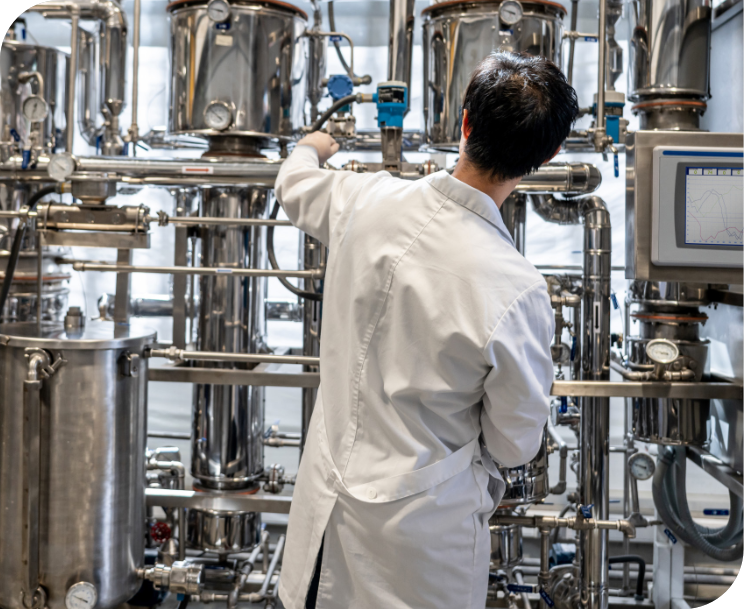 Man in lab coat working on distillery equipment