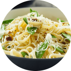 A bowl of pasta with fresh herbs and shredded parmesan cheese