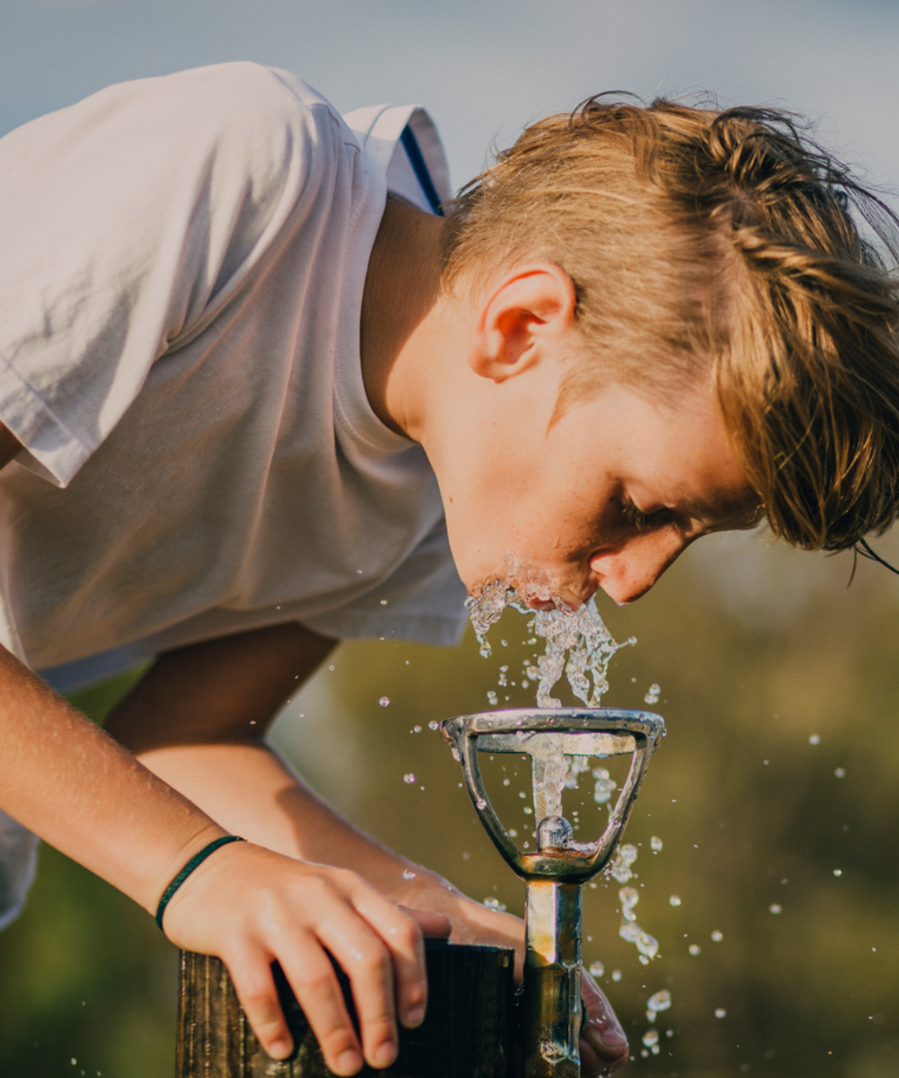 Young Boy Drinking from a Water Fountain