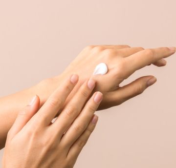 Hands applying cream