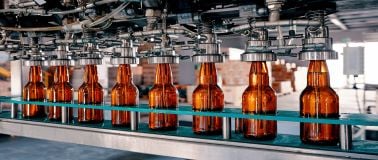 brown glass bottles on assembly line at an industrial manufacturing facility