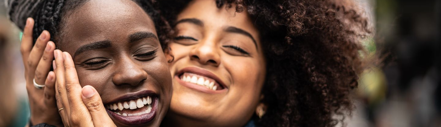 two woman posing to show off their thick hair