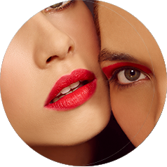 Two women wearing bright color cosmetics pose for the camera