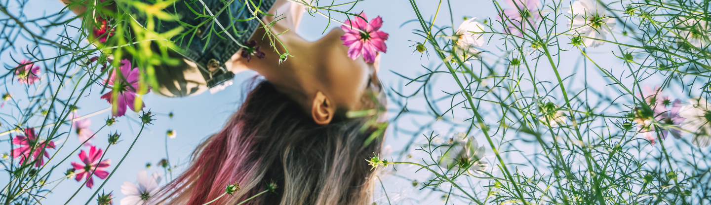 Woman exploring in a field of flowers with her hair flowing 