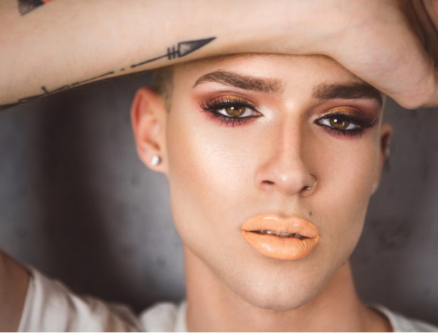 Male model wearing eye makeup and lipstick