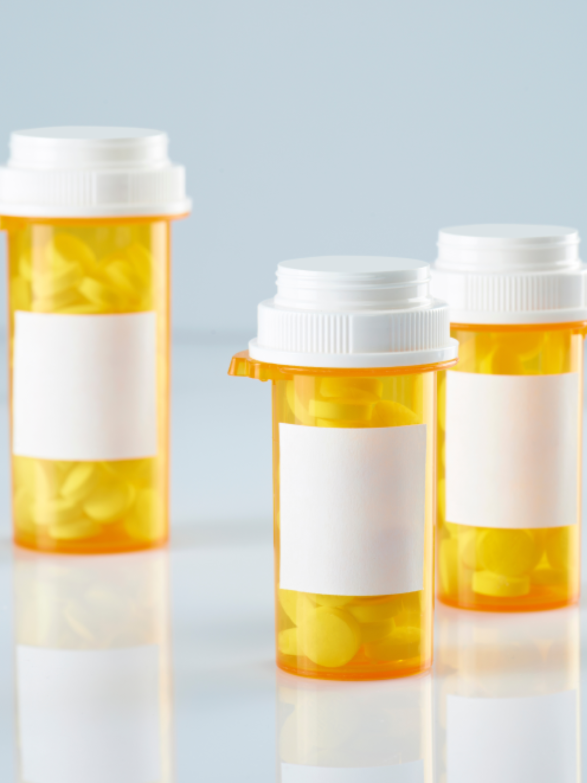 three prescription bottles full of medications
