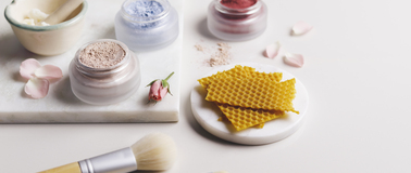 Assortment of natural beauty products with applicator brush and honey comb sheets