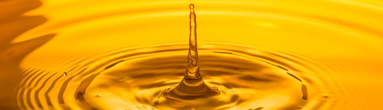 close up of a drop food safe oil on a yellow background