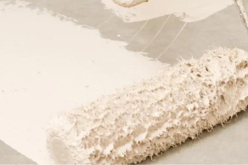 Paint roller soaked with white paint