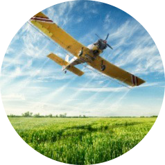 Agricultural aircraft flies over crops spraying agrochemicals such as herbicides and insecticides for pest control