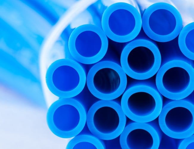 Blue tubes made from plastic additives are bundled together with a band