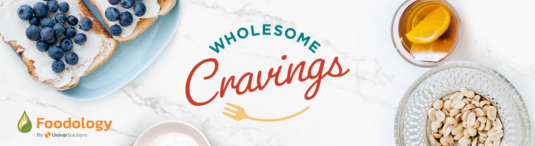 Healthier food and beverages on a marble table with the Foodology logo and the words "Wholesome Cravings"