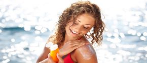 Woman applying sunscreen on the ocean shore